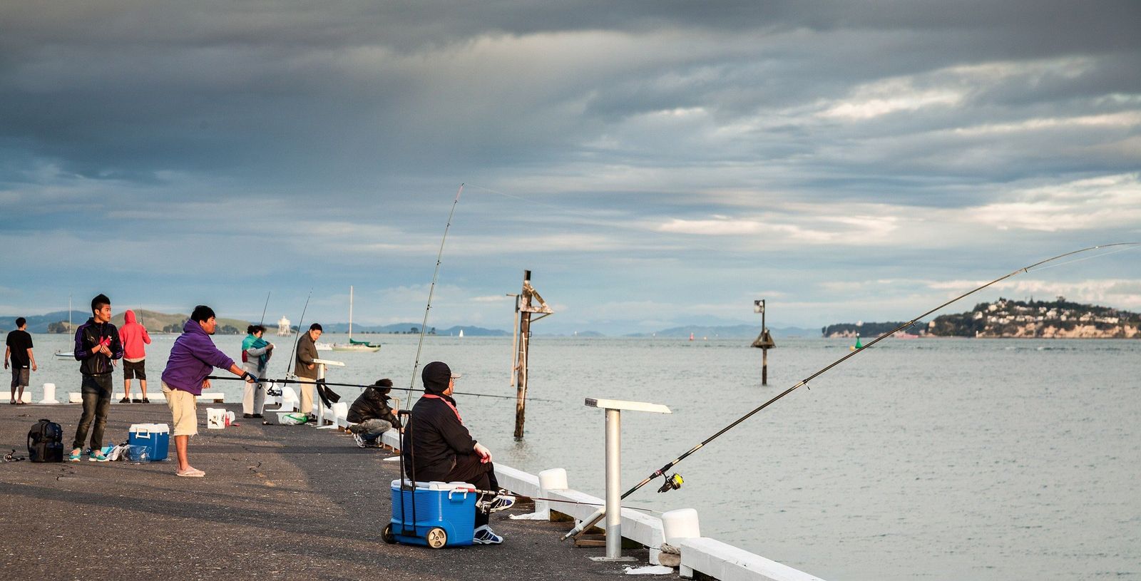 Two blue chilly bins among anglers on Devonport Wharf, Auckland