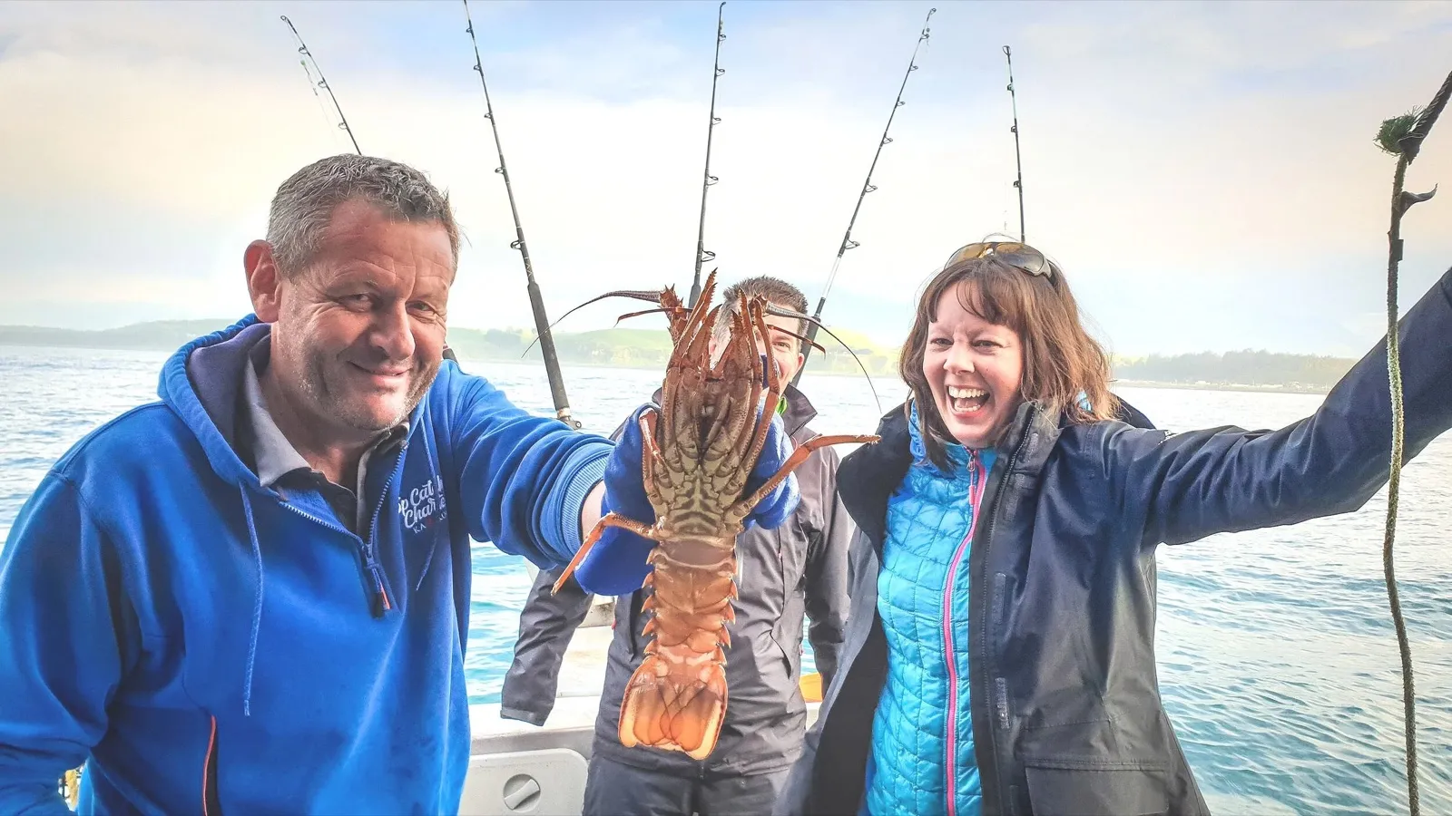 Anglers holding a crayfish aboard a Top Catch charter, Kaikōura