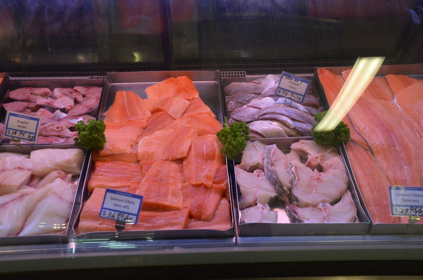 Snapper and salmon fillets and kingfish steaks in a fish market display, Auckland