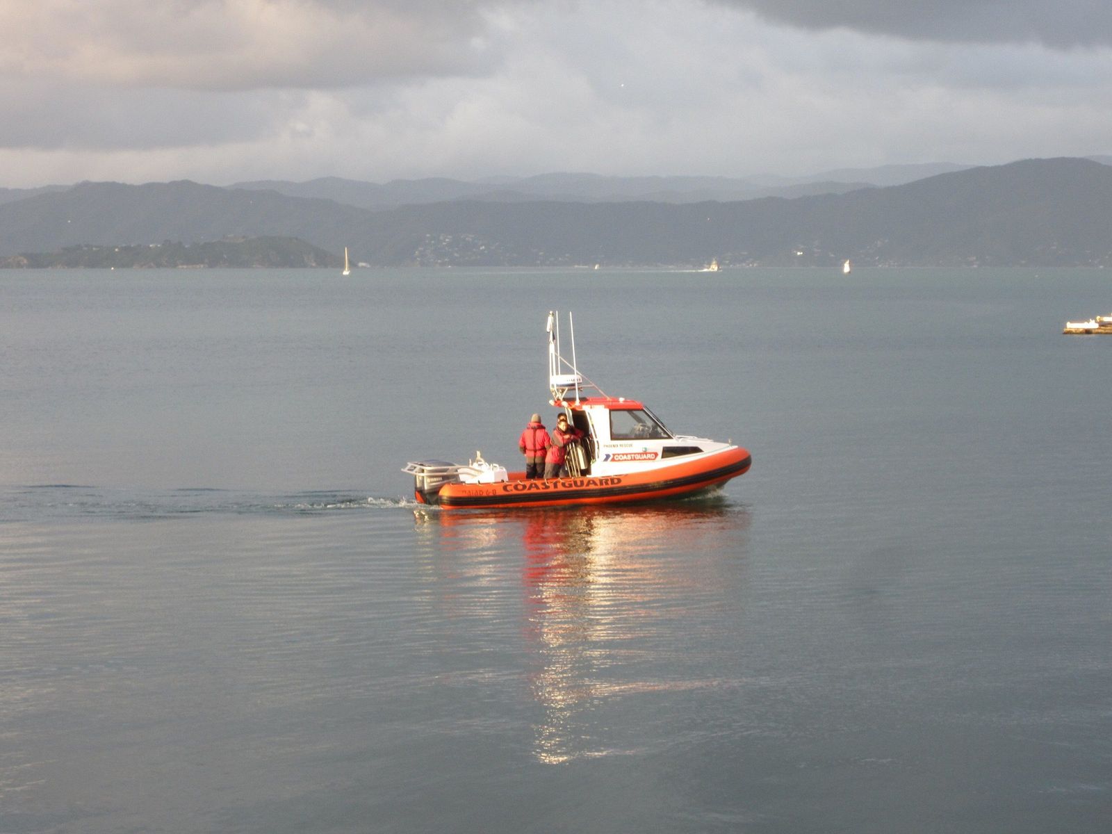 A Coastguard boat with its crew in lifejackets on Wellington Harbour