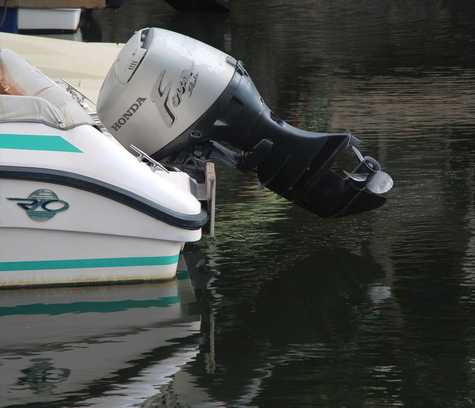 A four-stroke outboard motor tilted up on the transom of a small boat